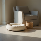 Plush round dog bed with a raised edge on a wooden floor